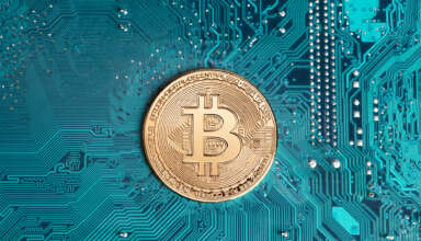 Golden bitcoin replica on computer circuit board